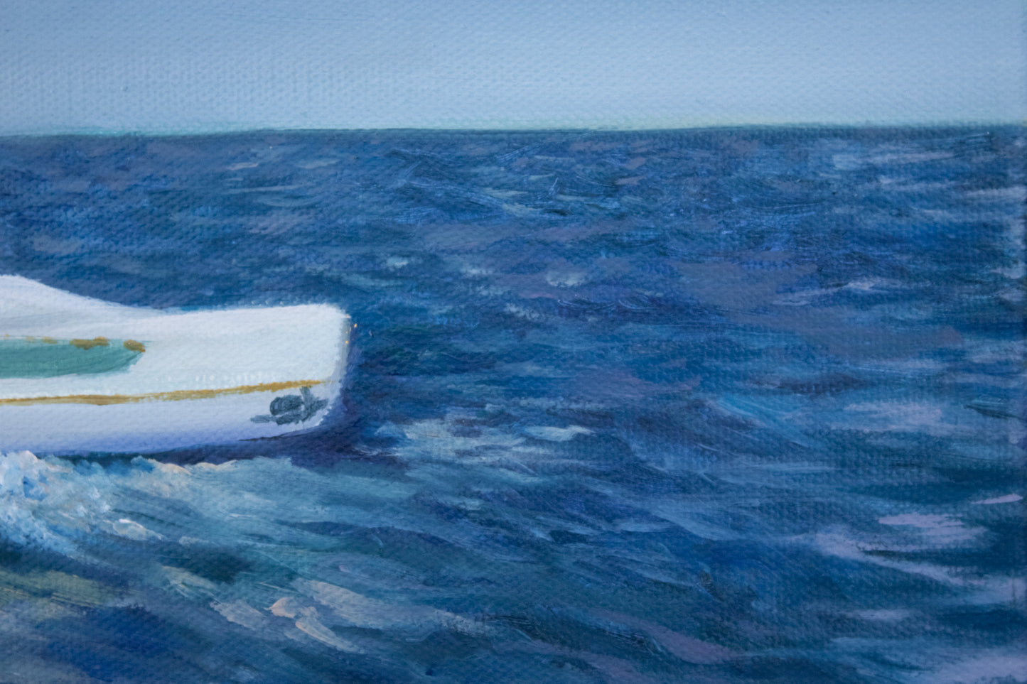 Small boat on a large body of water with a clear sky close up