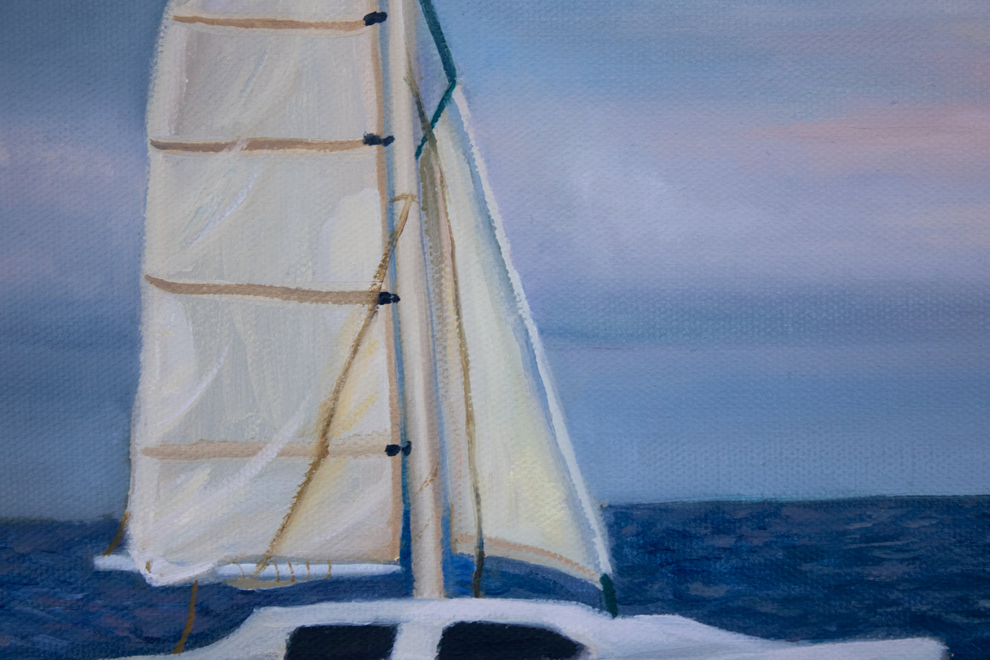 Close-up of a sailboat with white sails on a blue ocean and sky background
