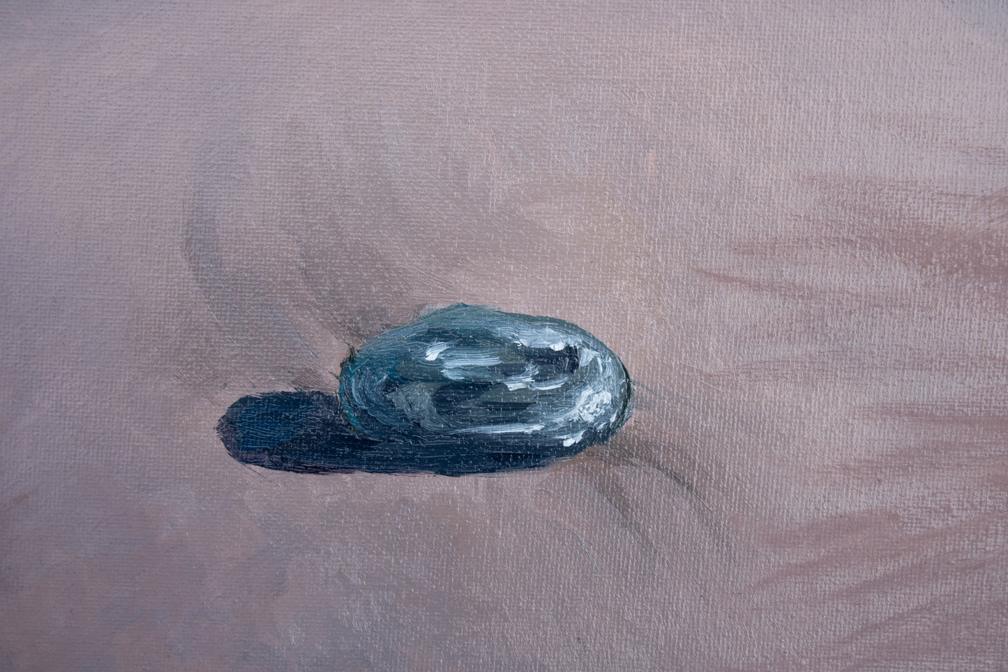 Blue oval rock on a textured beige surface