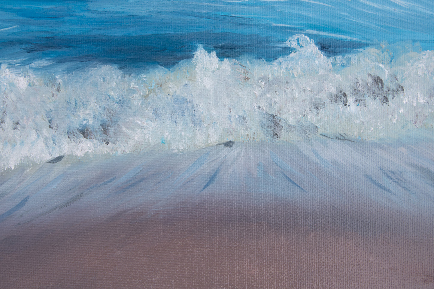 Close-up of a wave crashing onto a sandy beach