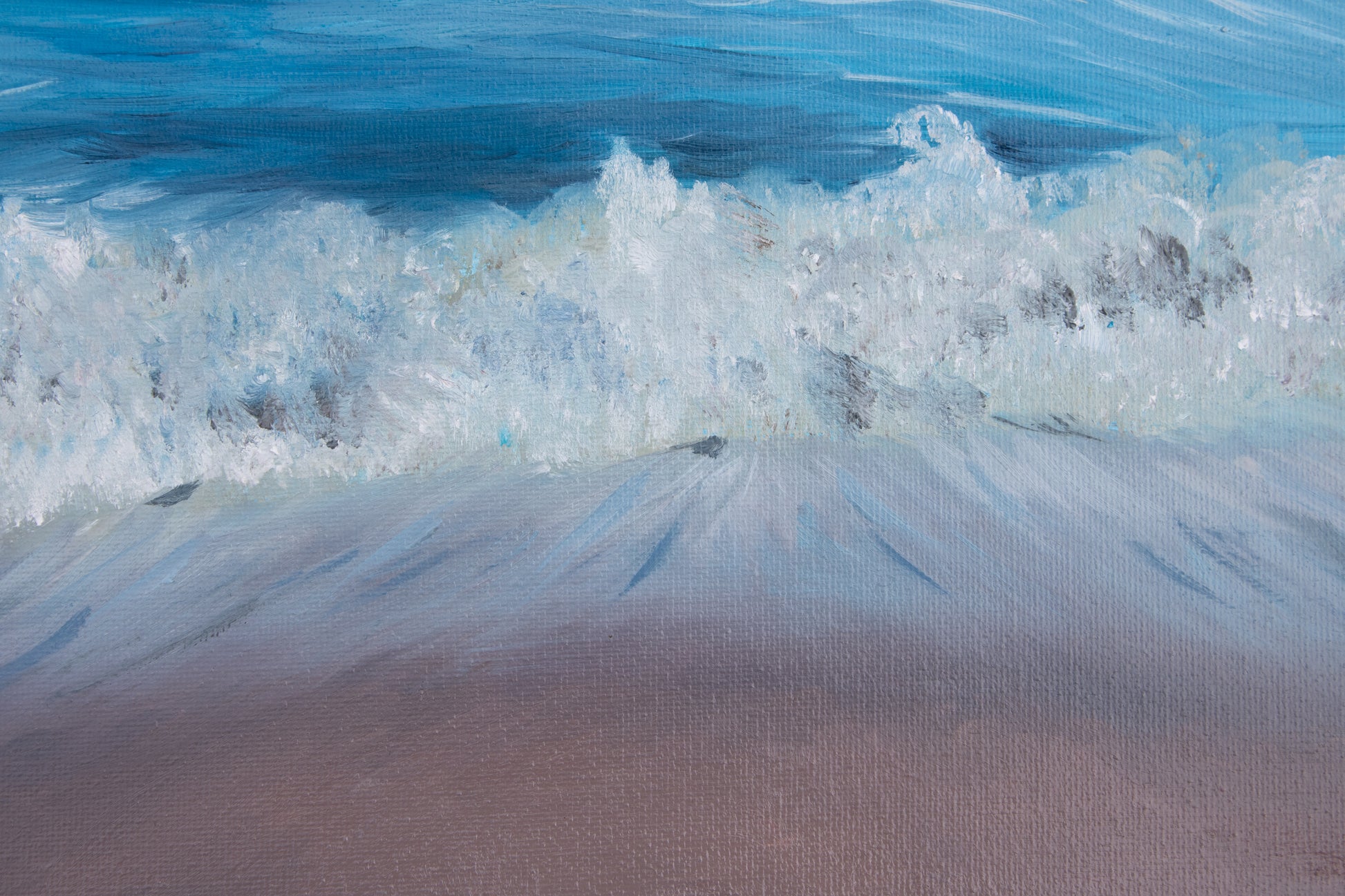 Close-up of a wave crashing onto a sandy beach