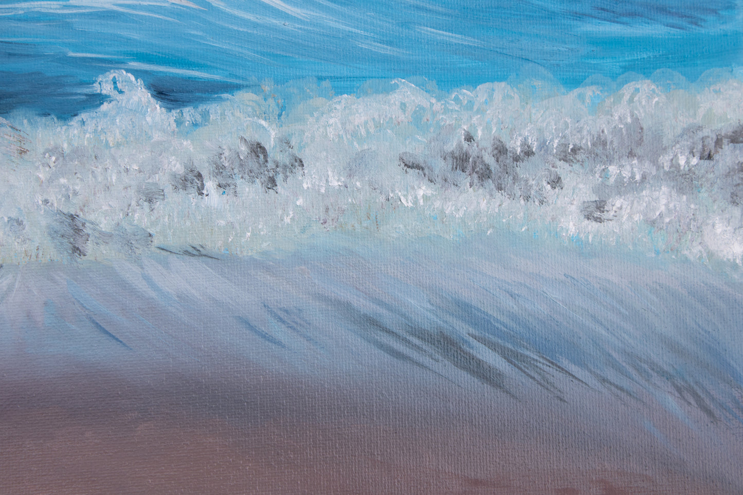 Close-up of ocean waves crashing onto a sandy beach