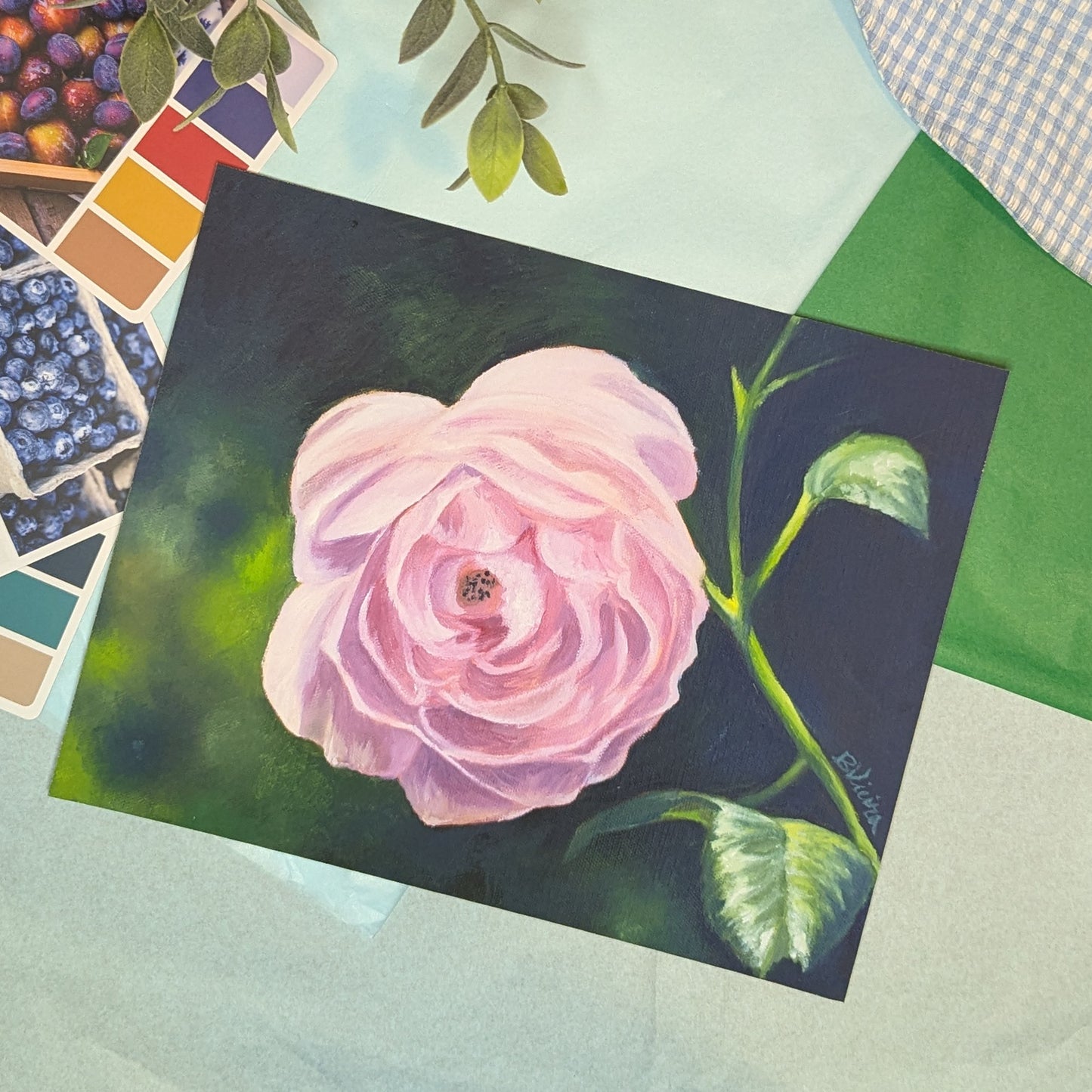 Painting print of a pink flower on a textured surface with color swatches.