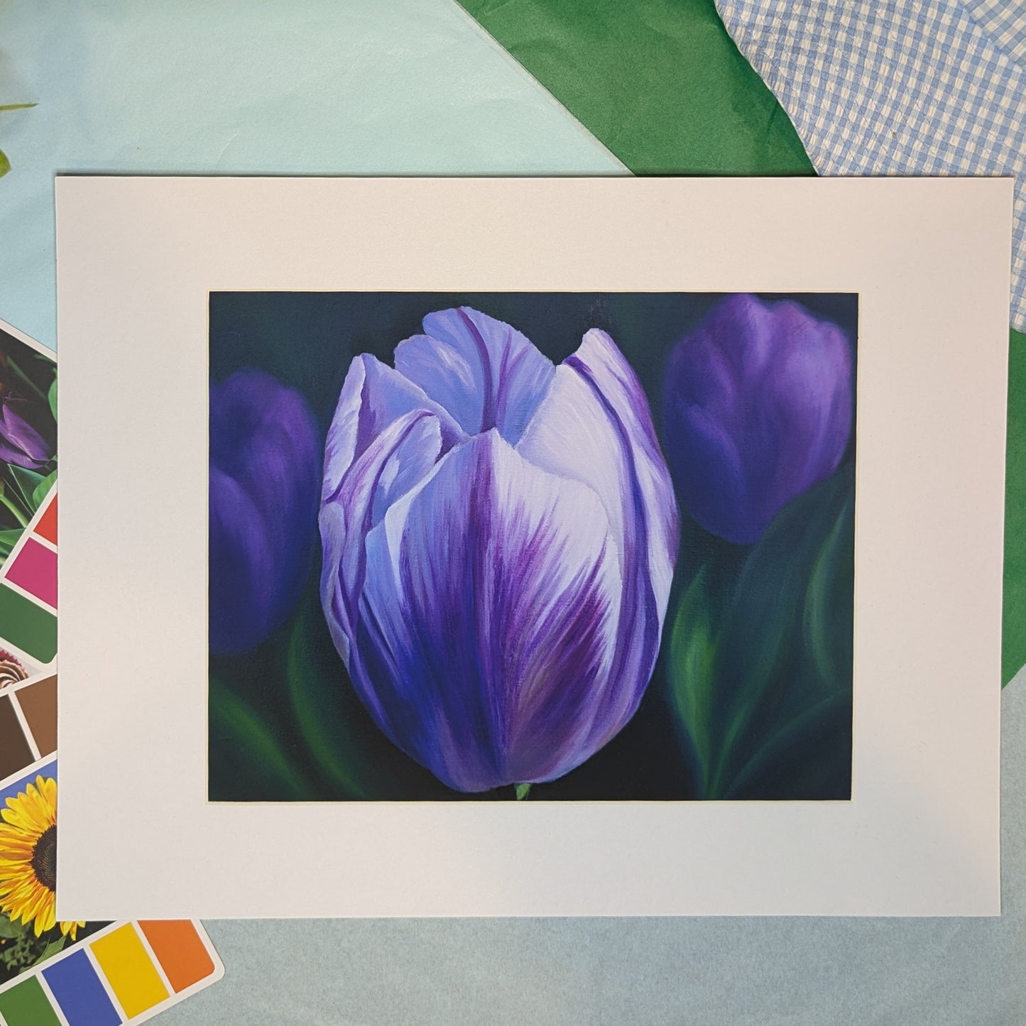 Matted print of a painting of a purple tulip on a colorful background