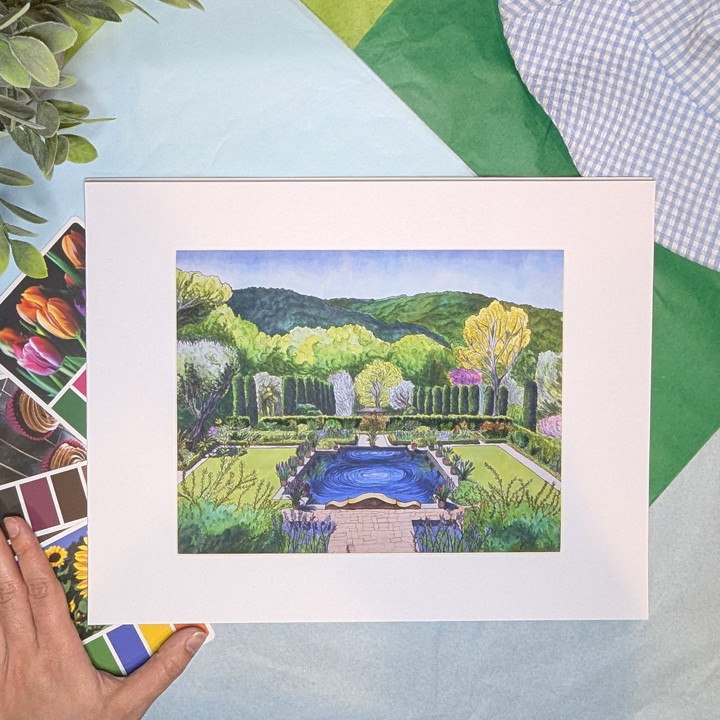 Artistic depiction of a garden scene with a pool, framed on a colorful background.