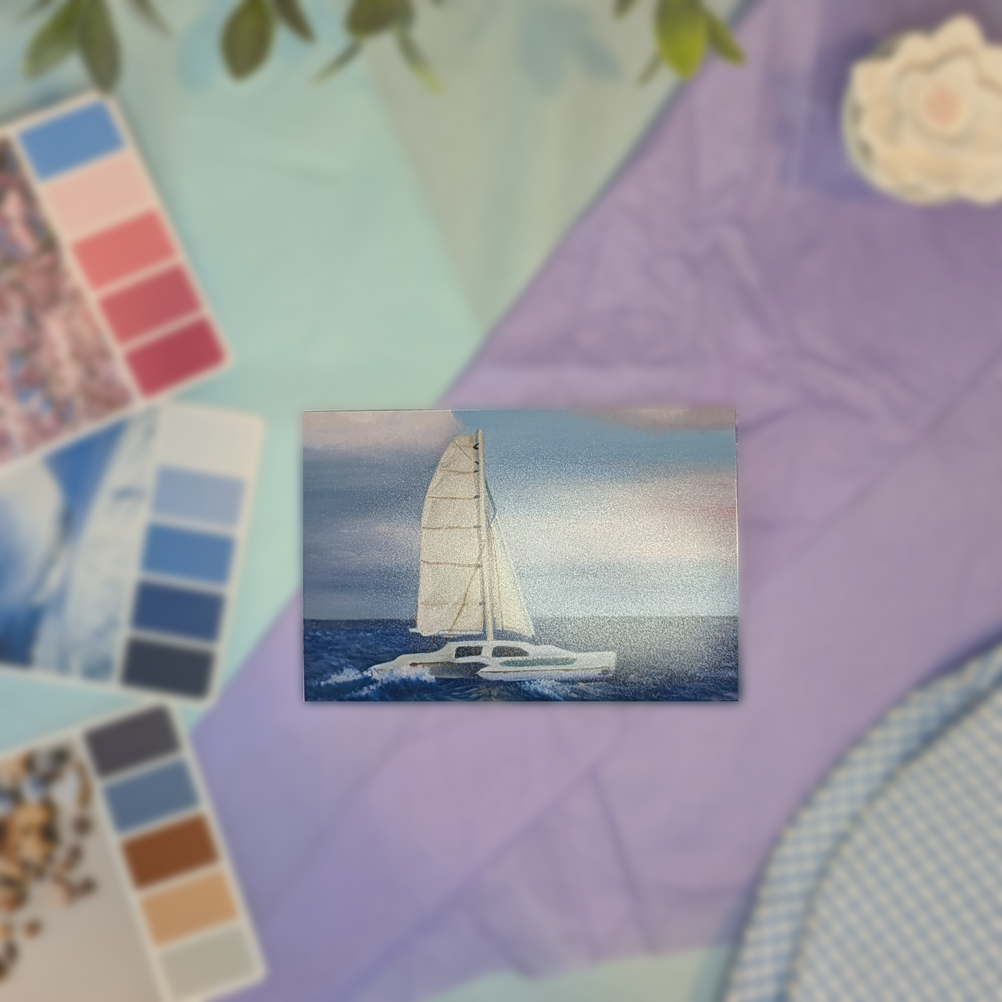 Small painting of a sailboat on a colorful textured background
